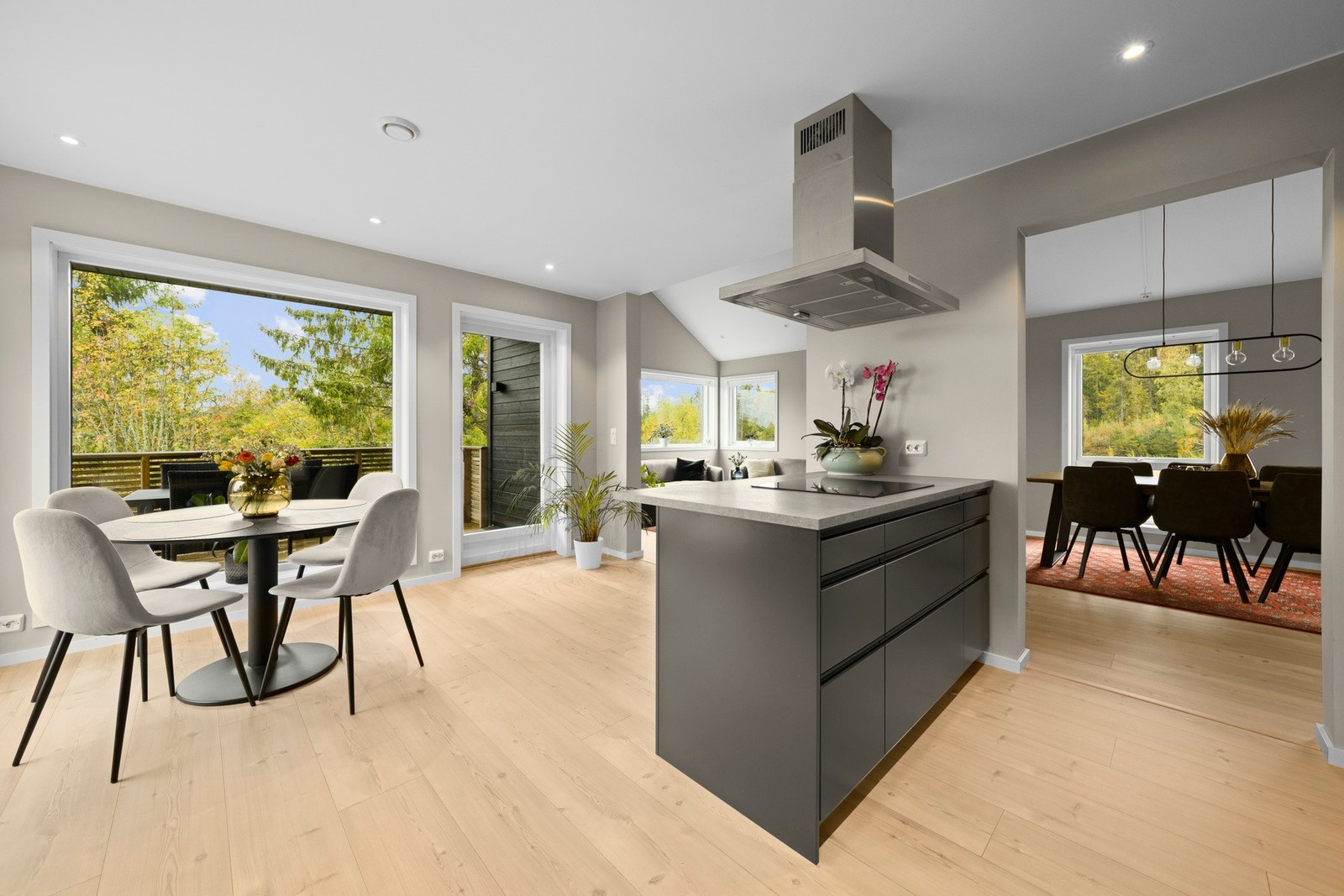 Kjøkkenet har en moderne innredning med glatte fronter, laminat benkeplate og integrerte hvitevarer som oppvaskmaskin, komfyr, induksjonstopp og kjøl/frys. Galleribilde