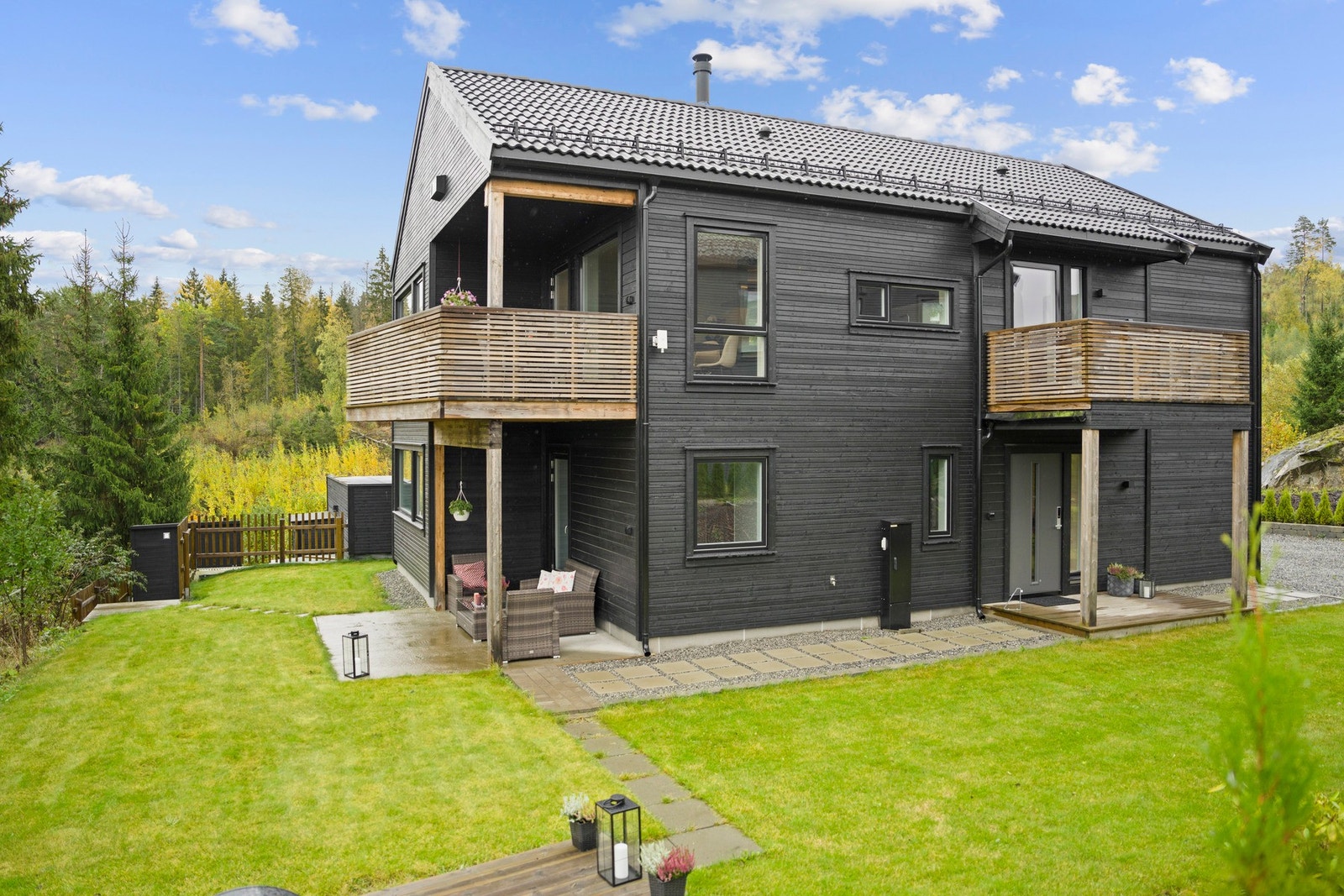 Den pent opparbeidede hagen omkranser boligen og byr på lune soner, grønne plener og plass til både lek og rekreasjon Galleribilde