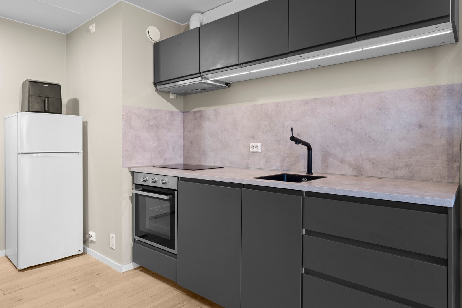 Kjøkkenet har glatte fronter, laminat benkeplate, oppvaskmaskin, komfyr og induksjonstopp med avtrekk Galleribilde