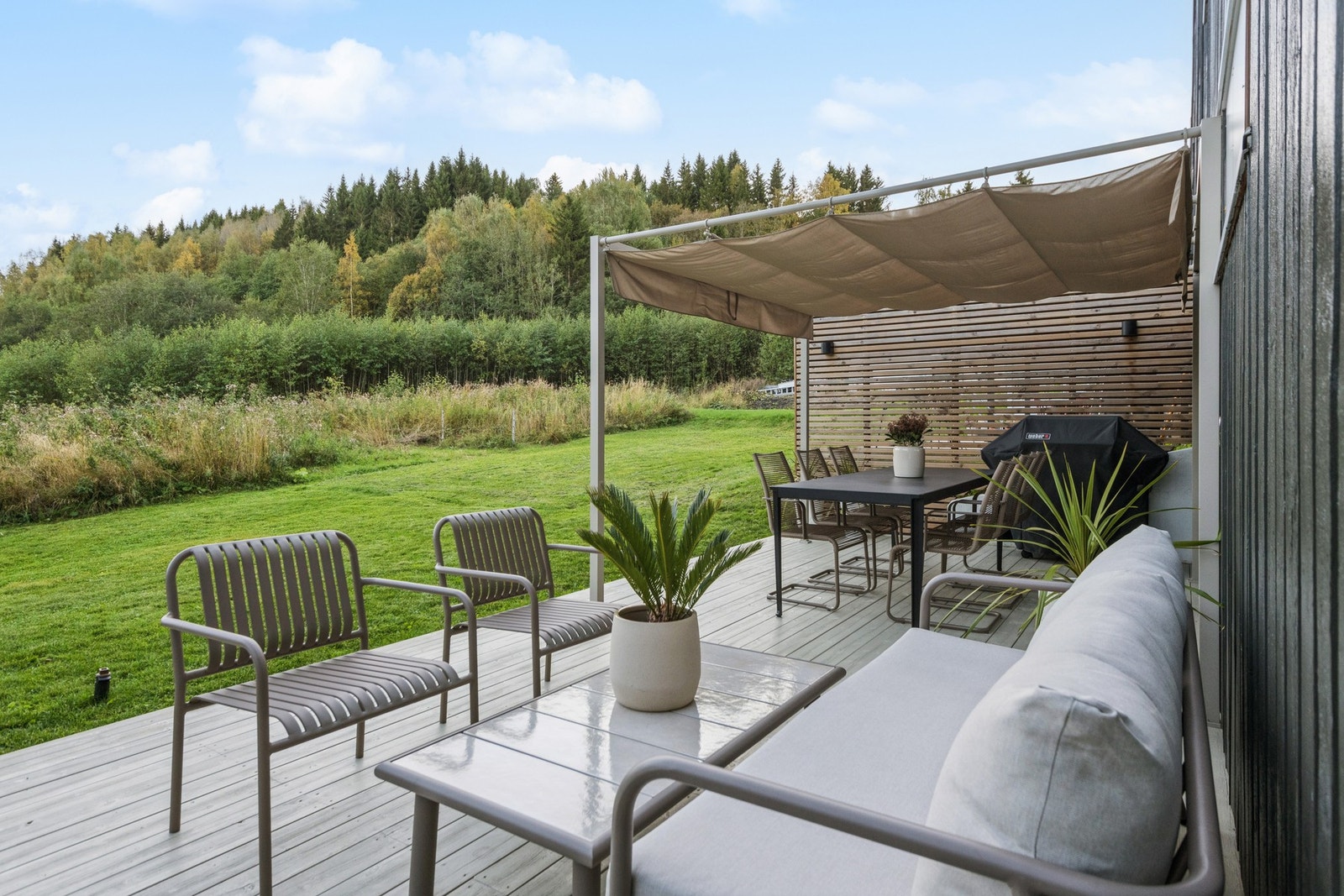 På baksiden har man flere hyggelige sitteplasser og en velholdt hage med plen og prydbusker. Galleribilde