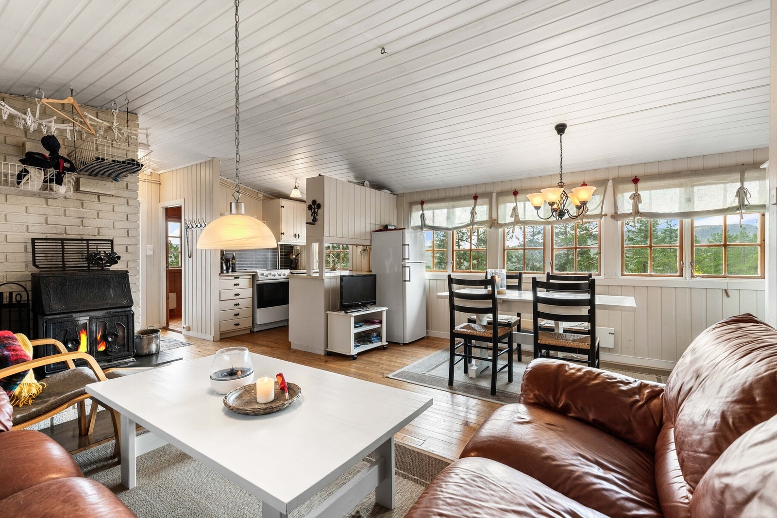 Den åpne løsningen mot kjøkken gir en sosial og lun atmosfære, perfekt for familiehygge og rolige helger Galleribilde