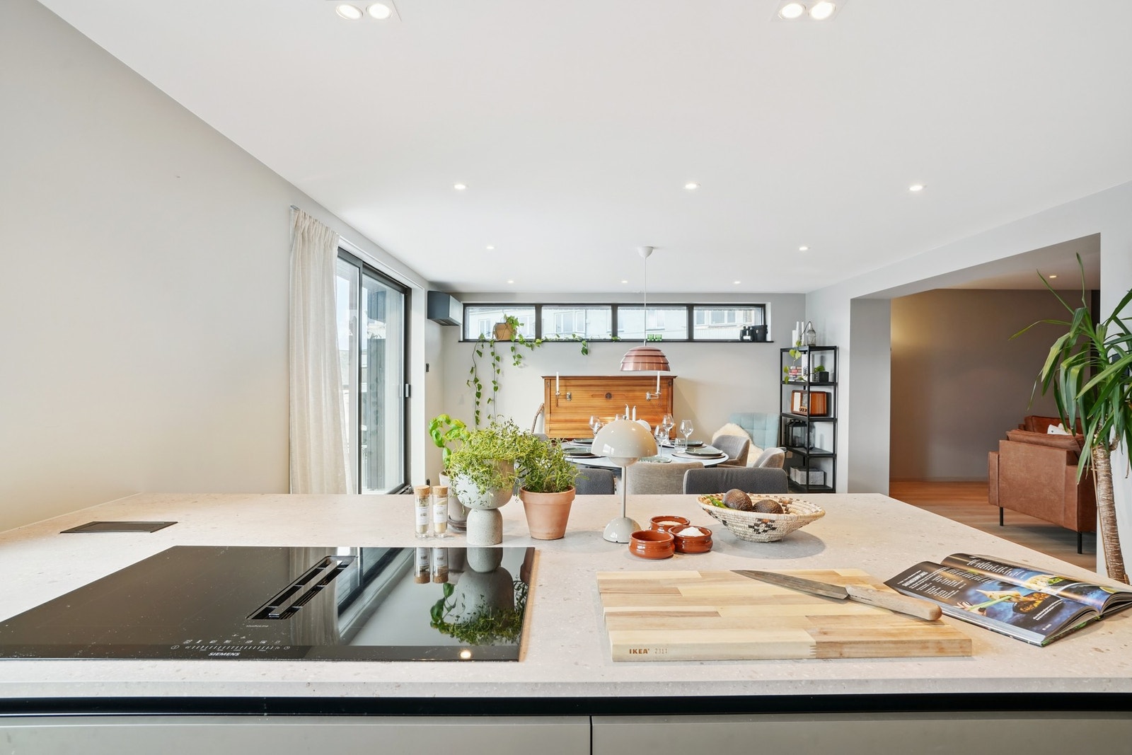 Hjemmets hjerte - et kjøkken som glir sømløst over i en innbydende stue og spiseplass. Galleribilde