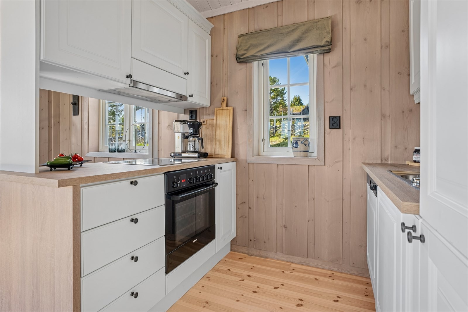 Kjøkkeninnredningen ble malt i 2024, og er pent utført med hvite, profilerte fronter og laminert benkeplate fra 2024 med nedfelt, dobbel kjøkkenkum. Galleribilde