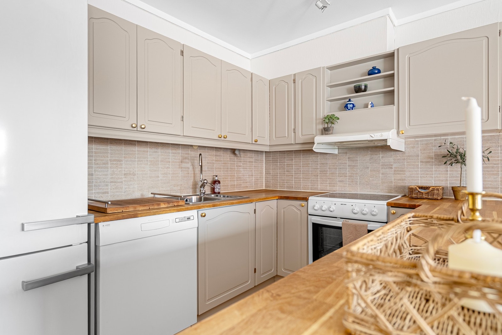 Tidløs kjøkkeninnredning med malte profilerte fronter og benkeplate av heltre Galleribilde