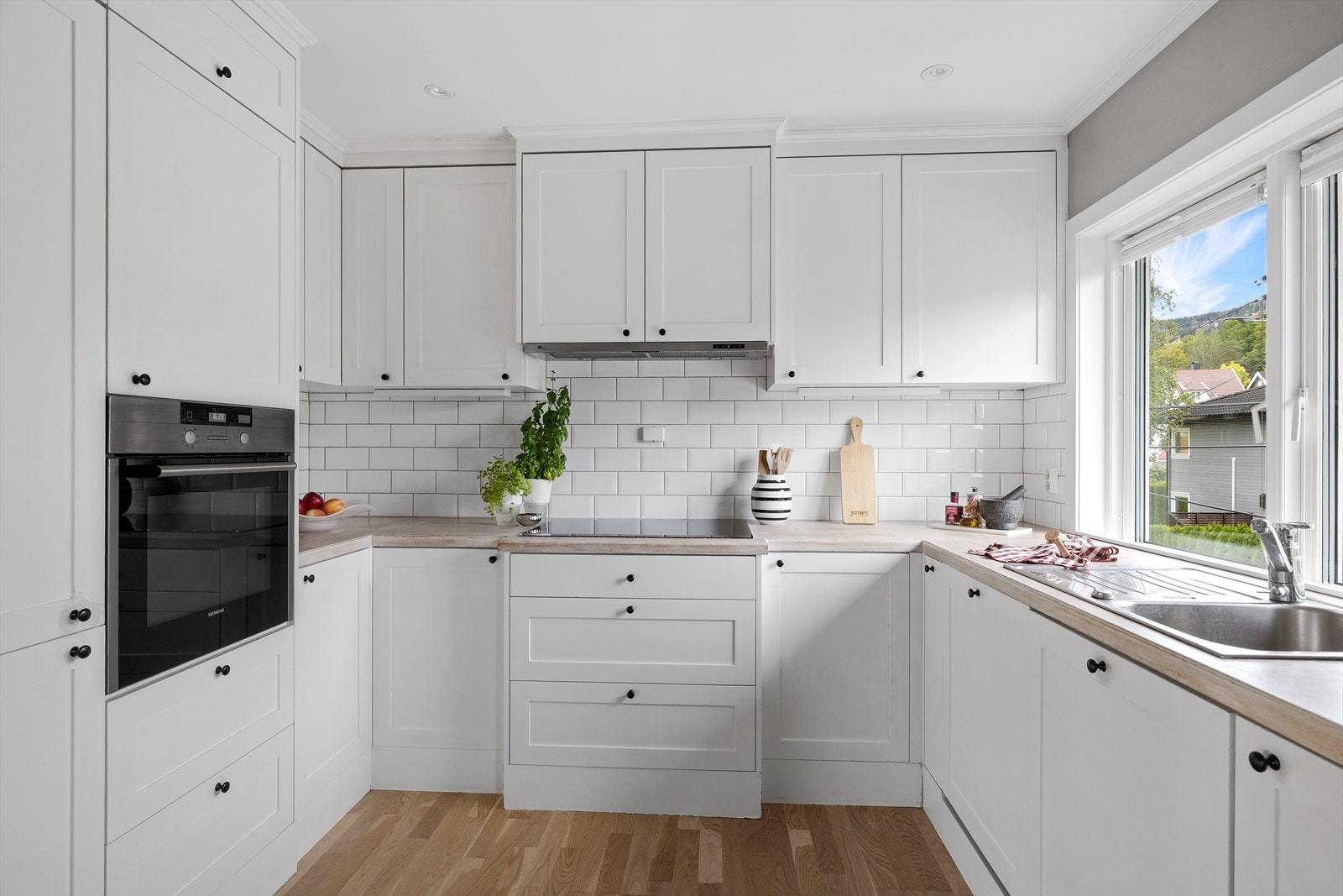 Moderne kjøkkeninnredning fra 2013 med profilerte fronter og heltre benkeplate med nedfelt oppvaskkum Galleribilde