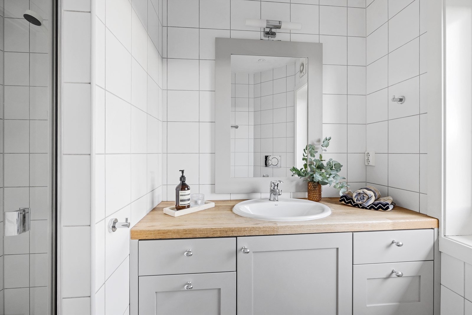 Badet er innredet med vegghengt toalett og dusjnisje, samt baderomsinnredning med heltre benkeplate og nedfelt servant Galleribilde