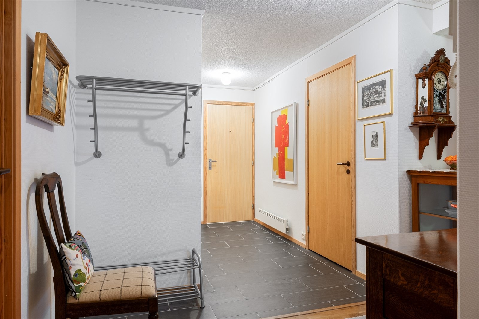 Lys og innbydende gang med flislagt gulv og god plass til oppbevaring Galleribilde