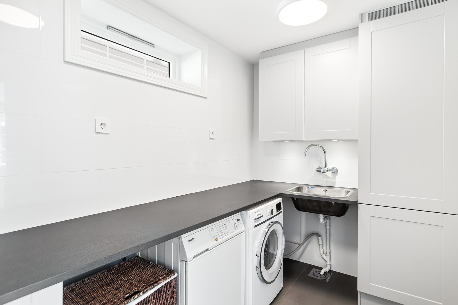 Eget vaskerom står høyt på mange barnefamiliers ønskeliste. Her får du et praktisk vaskerom med mye benkeplass og oppbevaringsplass. Det er sentralstøvsuger i boligen. Galleribilde