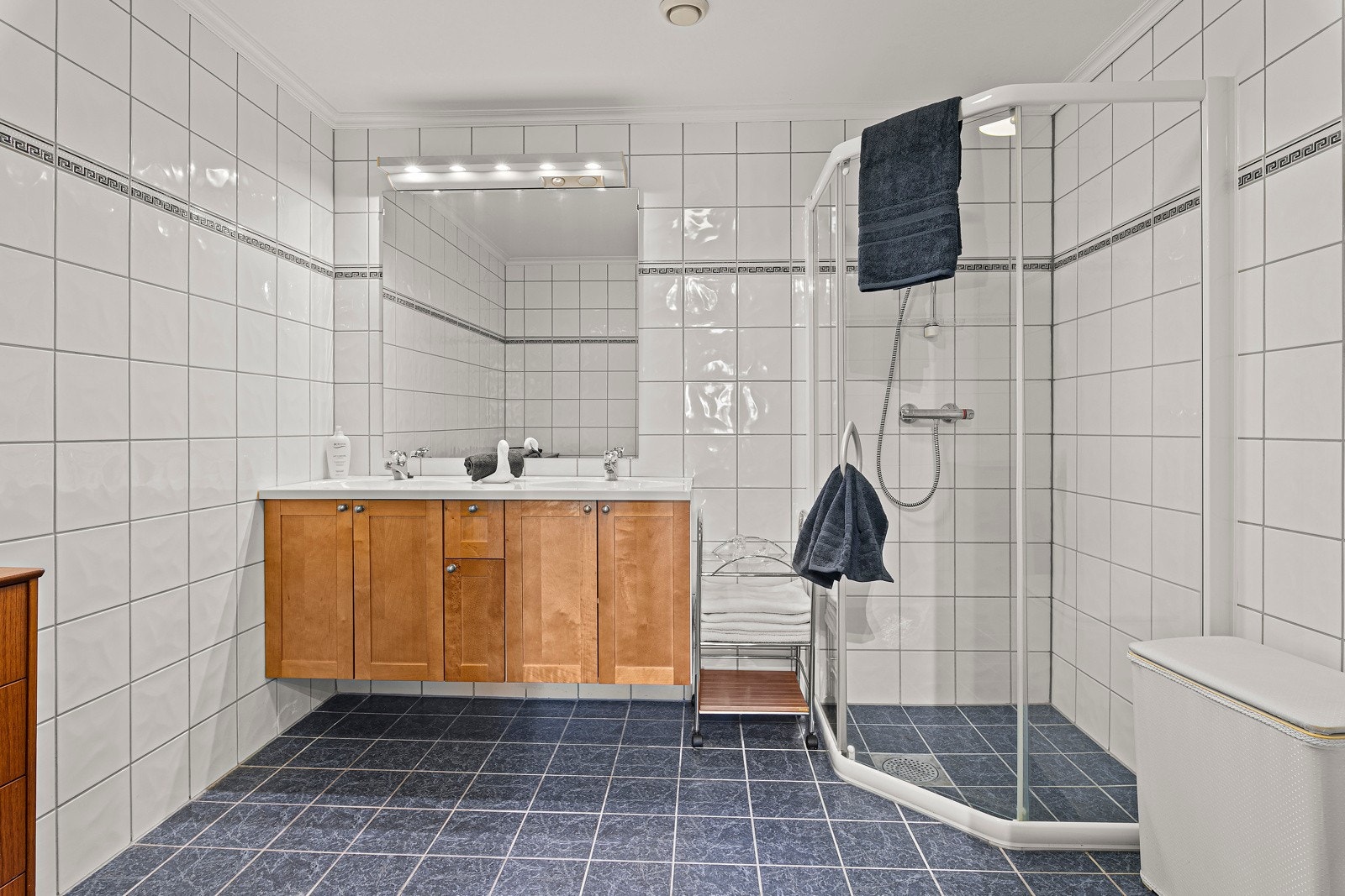 Stort innbydende bad med dusjnisje, servant med underskap og toalett Galleribilde