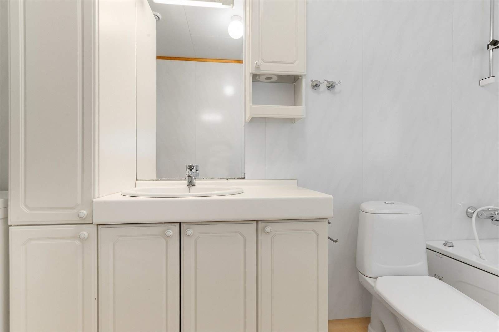 Badet er innredet med badekar, gulvmontert toalett og baderomsinnredning med nedfelt servant. Galleribilde