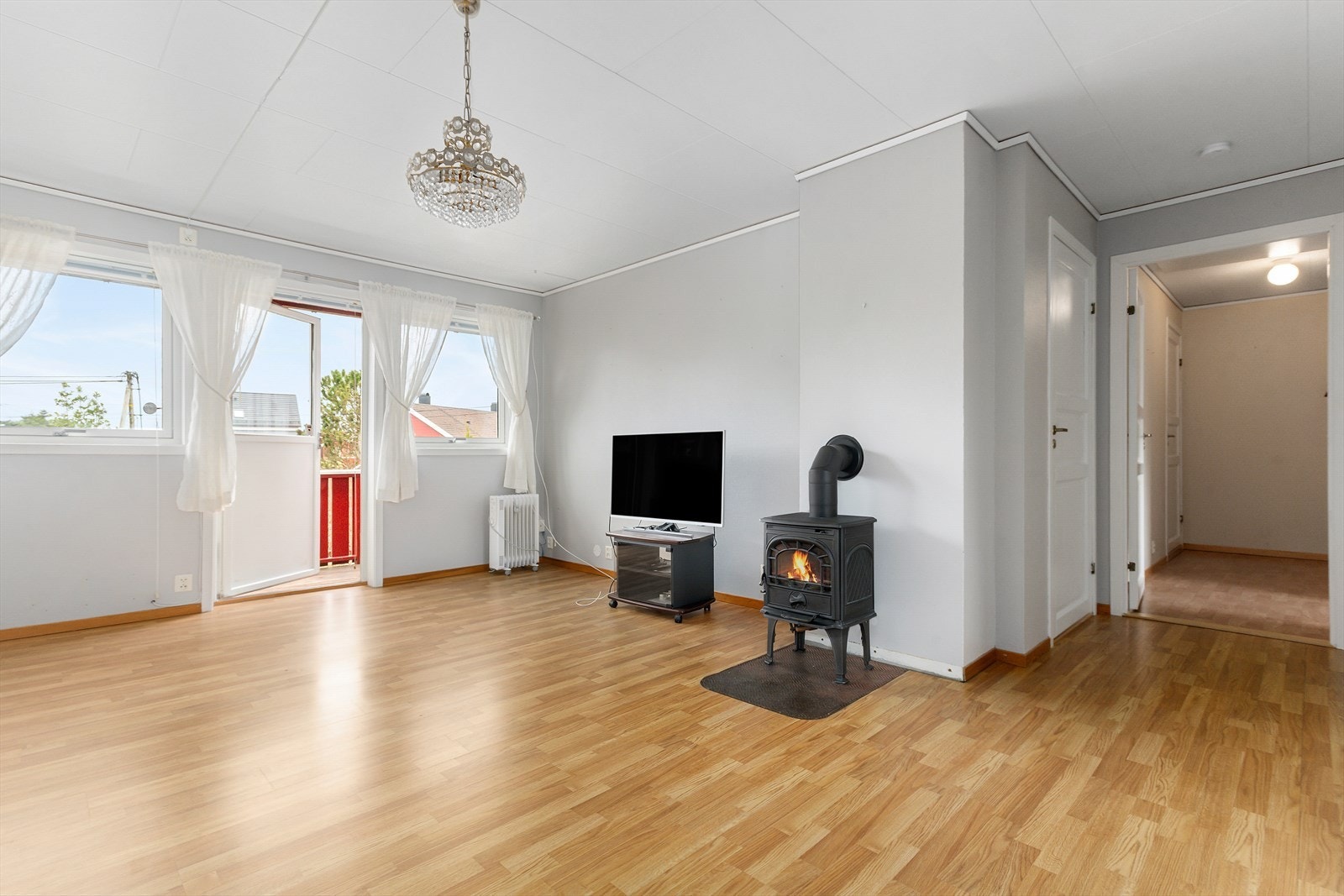 Lys og romslig stue med laminat på gulv. Galleribilde