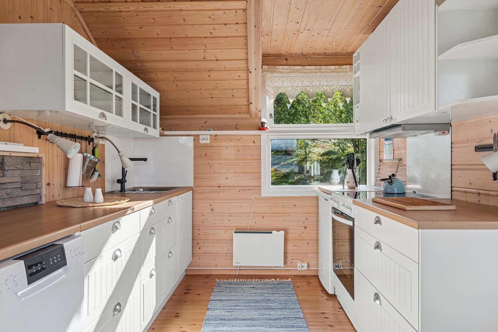 Kjøkkenet har en innredning med profilerte fronter, kombinert med enkelte overskap med glassfronter som gir et lyst og åpent uttrykk. Benkeplaten er i slitesterk laminat. Galleribilde