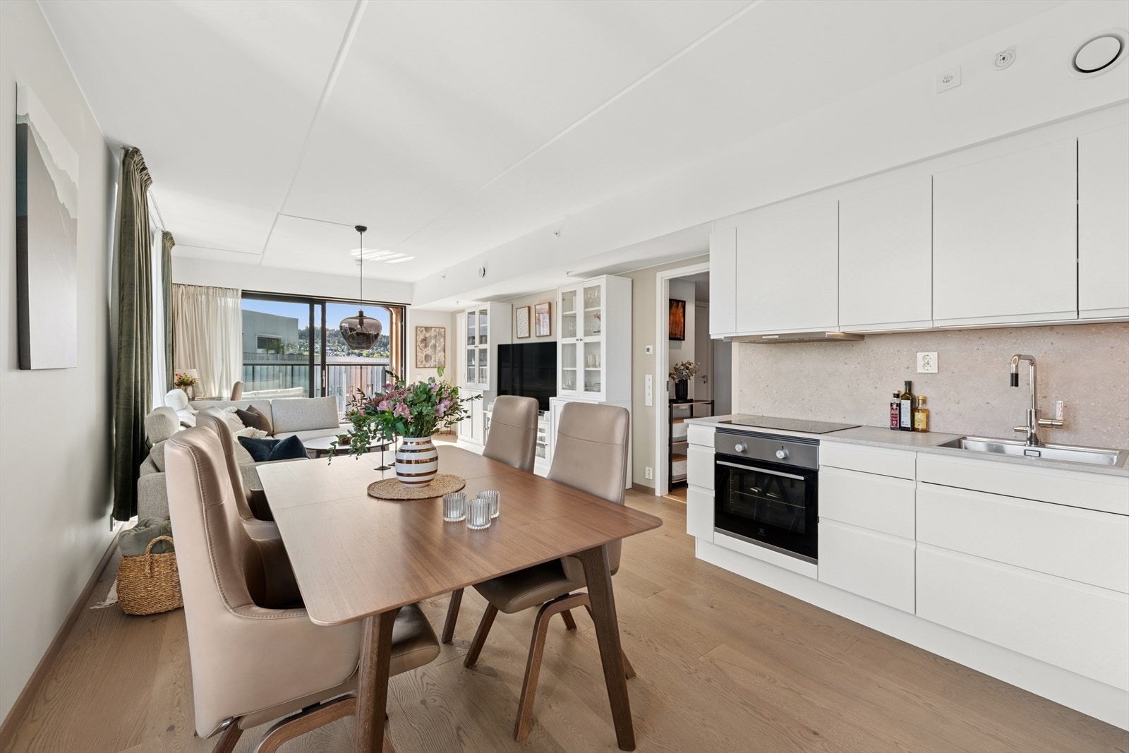 Allrommet med kjøkken, spisestue og stue er leilighetens selvskrevne samlingspunkt. Galleribilde