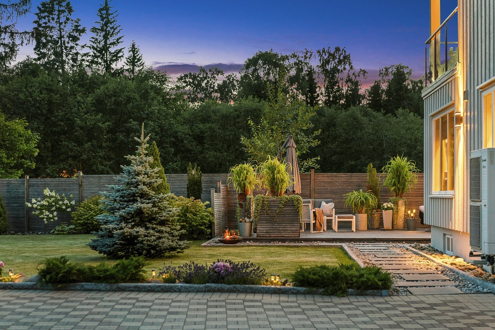 Blomster, busker og trær pryder tomten, og hellelagte gangstier
gjør det enkelt å gå rundt hele boligen. Galleribilde