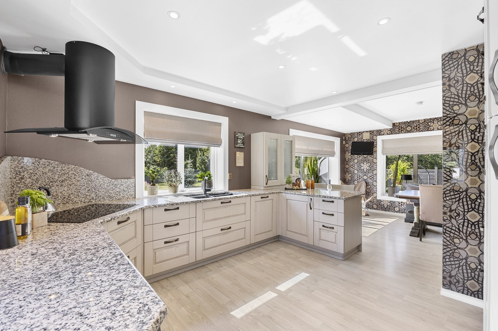 Kjøkkenet har lyse profilerte fronter, elegante vitrineskap, og lekre benkeplater av marmor med avrundede kanter. Galleribilde