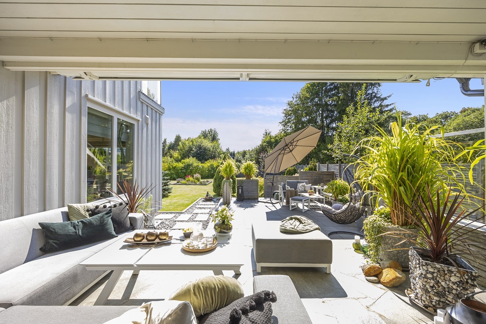 Fra denne stuen er det utgang til delvis overbygget terrasse med en praktisk elektrisk markise, perfekt for solrike dager. Galleribilde