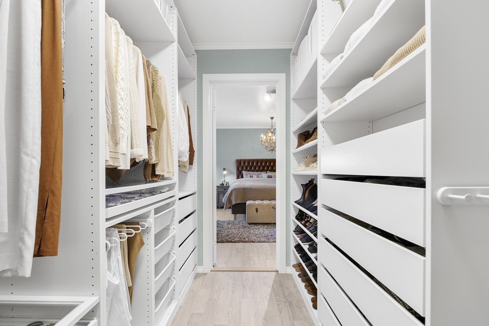 Tilknyttet soverommet finner du en luksuriøs walk-in-garderobe, komplett med åpne garderobeløsninger, skoskap, oppheng, hyller og skuffer Galleribilde