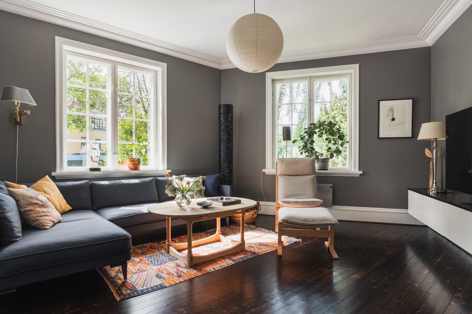 Stuene har luftig takhøyde, stilren stukkatur og brede fotlister som understreker den klassiske stilen. Galleribilde