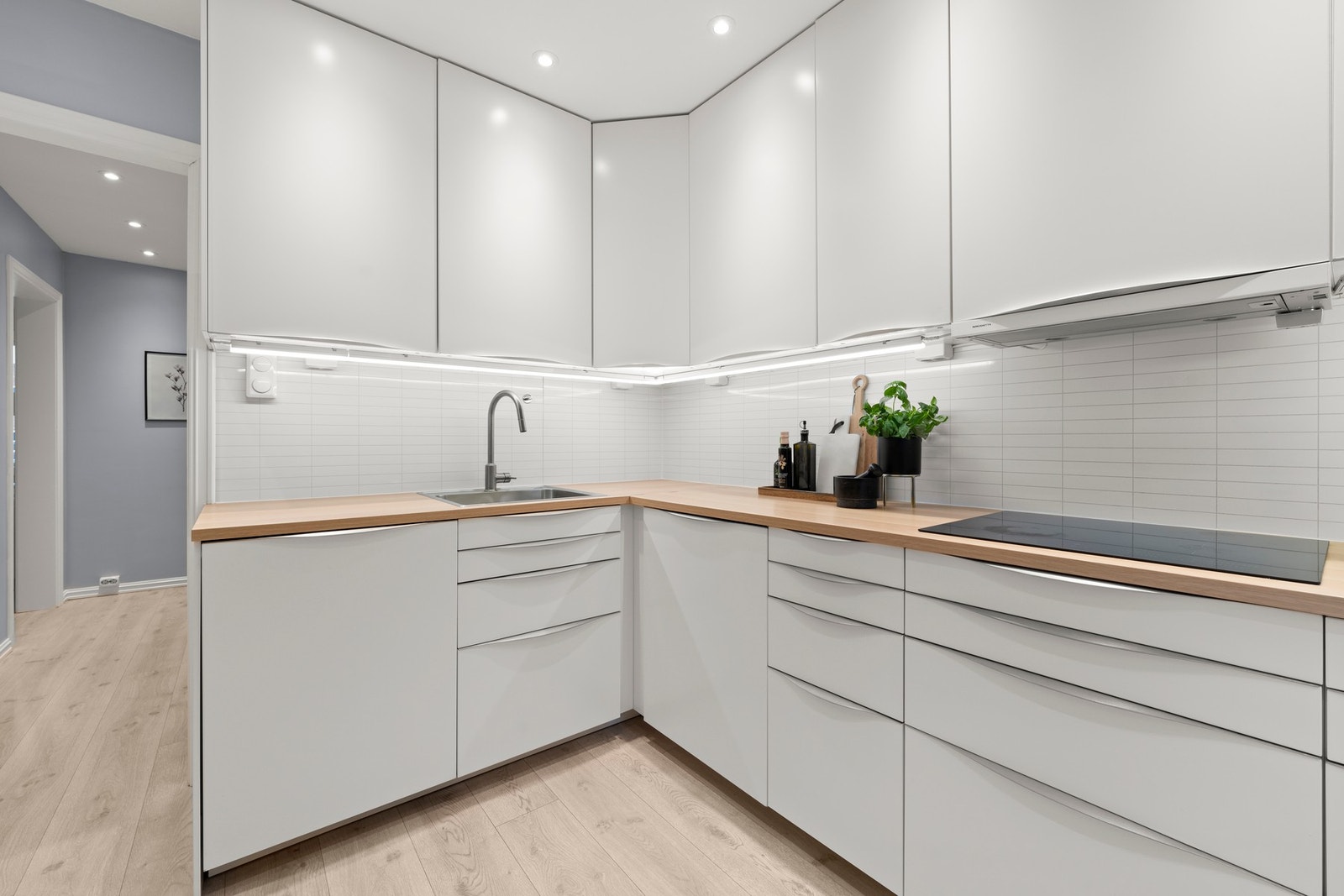 Kjøkkenet er fra Ikea, fra 2015. Kjøkkeninnredning med glatte fronter, laminat benkeplate og integrerte hvitevarer, som platetopp, stekeovn, oppvaskmaskin, kjøleskap og mikrobølgeovn. Galleribilde