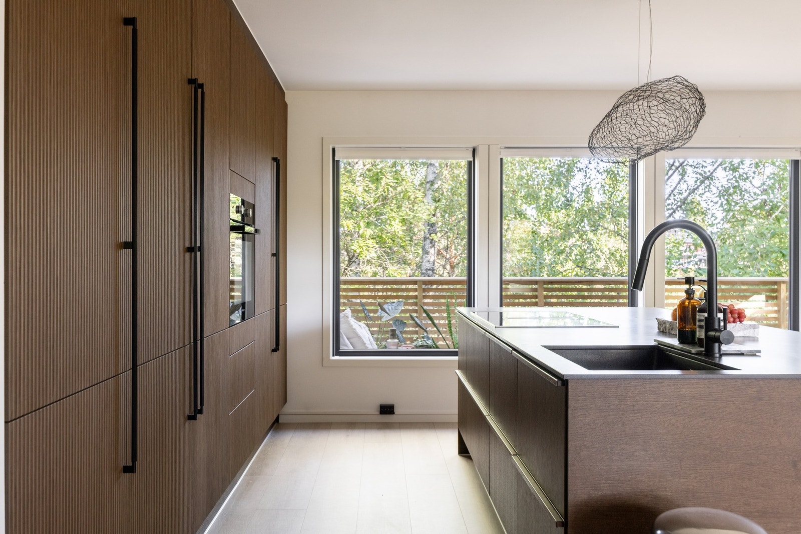 Induksjonstoppen med integrert ventilator er plassert på kjøkkenøyen og legger til rette for et sosialt miljø og god oversikt over resten av familien/gjester. Galleribilde