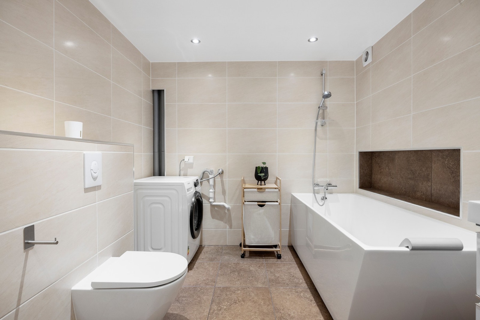 Boligens baderom fra 2015 er lyst og flislagt med varme i gulv samt downlights i himling. Det er opplegg for vaskemaskin og plass til tørketrommel. Galleribilde