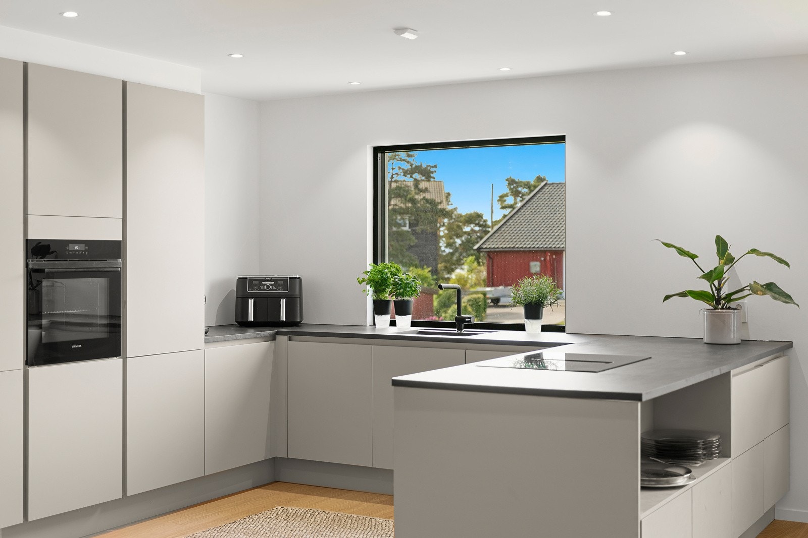 Kjøkkeninnredningen har slette fronter og laminert benkeplate, integrert kjøl/frys, oppvaskmaskin, ovn og platetopp Galleribilde