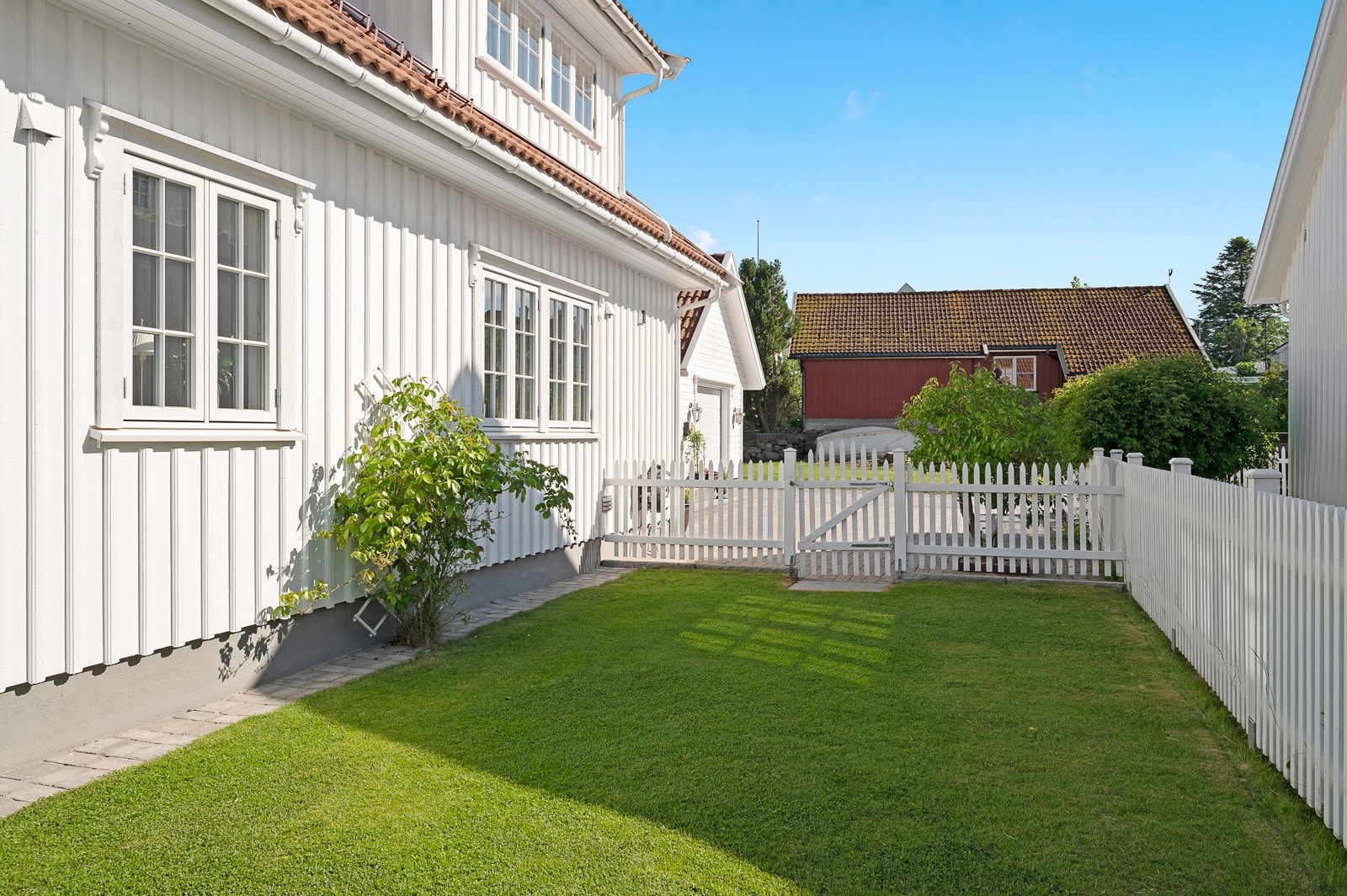 Det hvite stakittgjerde gir en fin innramming av eiendommen. Galleribilde