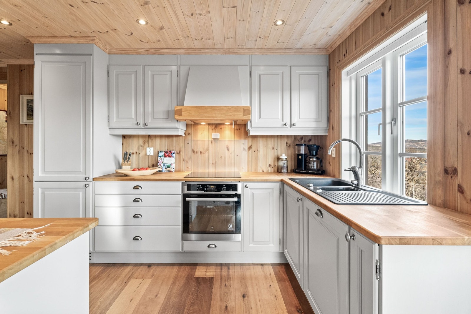 Lyst og trivelig kjøkken med Kistefos innredning, integrerte hvite- og brunevarer Galleribilde