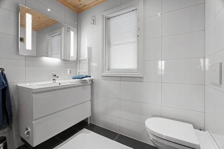 Hoved bad 1. etasje med med vegg-hengt toalett, flisbelagt dusj-nisje med waterfall dusj Galleribilde