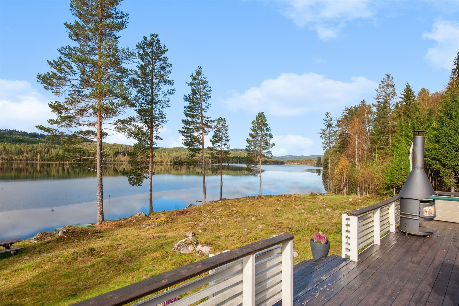 Fra den romslige terrassen har man en flott utsikt over vannet og de omkringliggende skogsområdene. Galleribilde