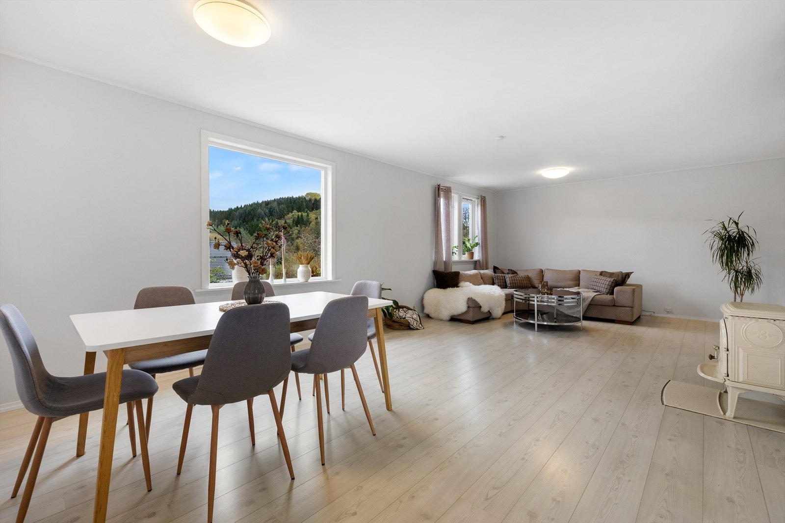 Romslig stue med plass til flere sittegrupper. Galleribilde