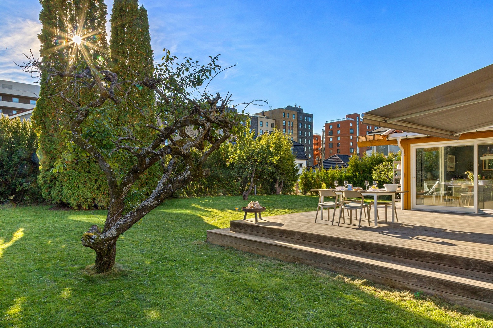 Tomten er frodig og pent opparbeidet med flere trær, busker og hekk. Galleribilde