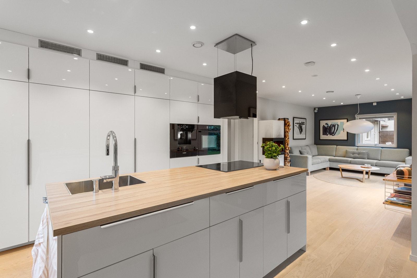 Lys, glatt innredning med laminat benkeplate og nedfelt kum med ett-greps blandebatteri. Galleribilde