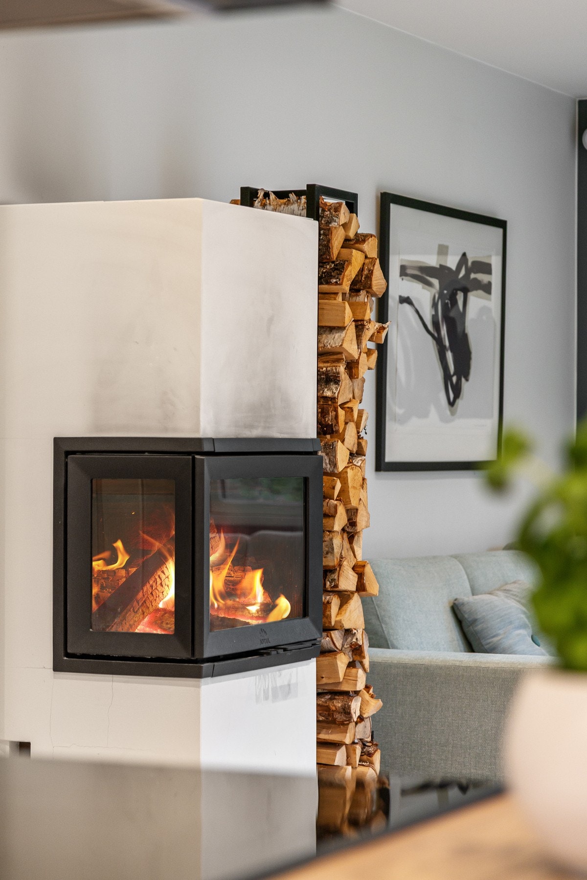 Den stilrene peisovnen midt i rommet bidrar ikke bare til varme og hygge på kaldere dager, men gir også en hyggelig romatmosfære. Galleribilde