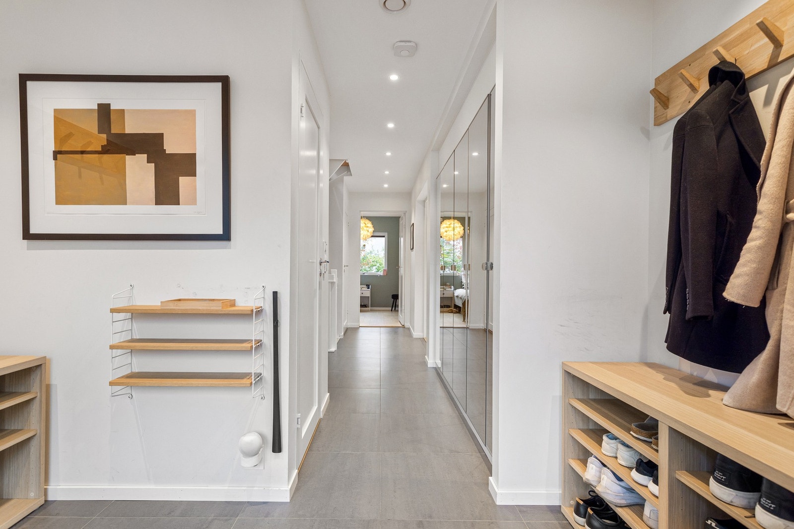 Entréen har fin plass for blant annet kommode, knaggrekker og speil. Plassbygget garderobeløsning med speilfronter blir stående. Galleribilde