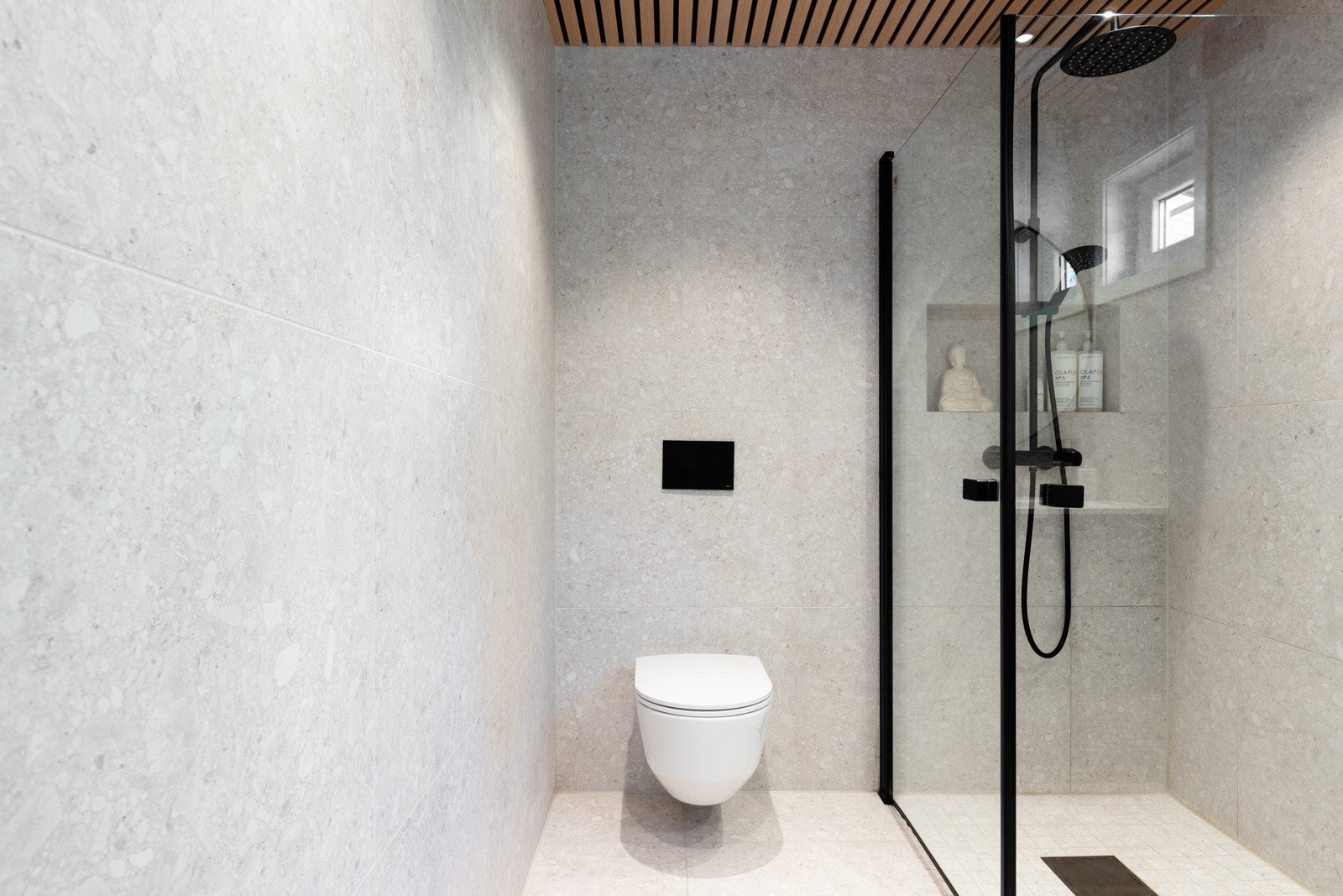 Rommet har fått et stilrent uttrykk med flotte spiler i himling med downlights, store 60X60 gulv -og veggfliser i terrazzo. Galleribilde