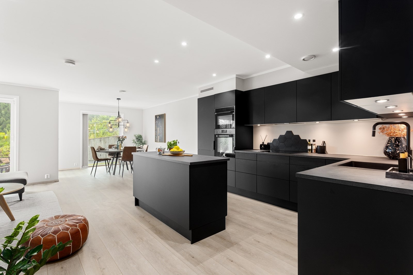 Stilrent kjøkken, innredning med glatte fronter. Benkeplaten er av laminat. Galleribilde