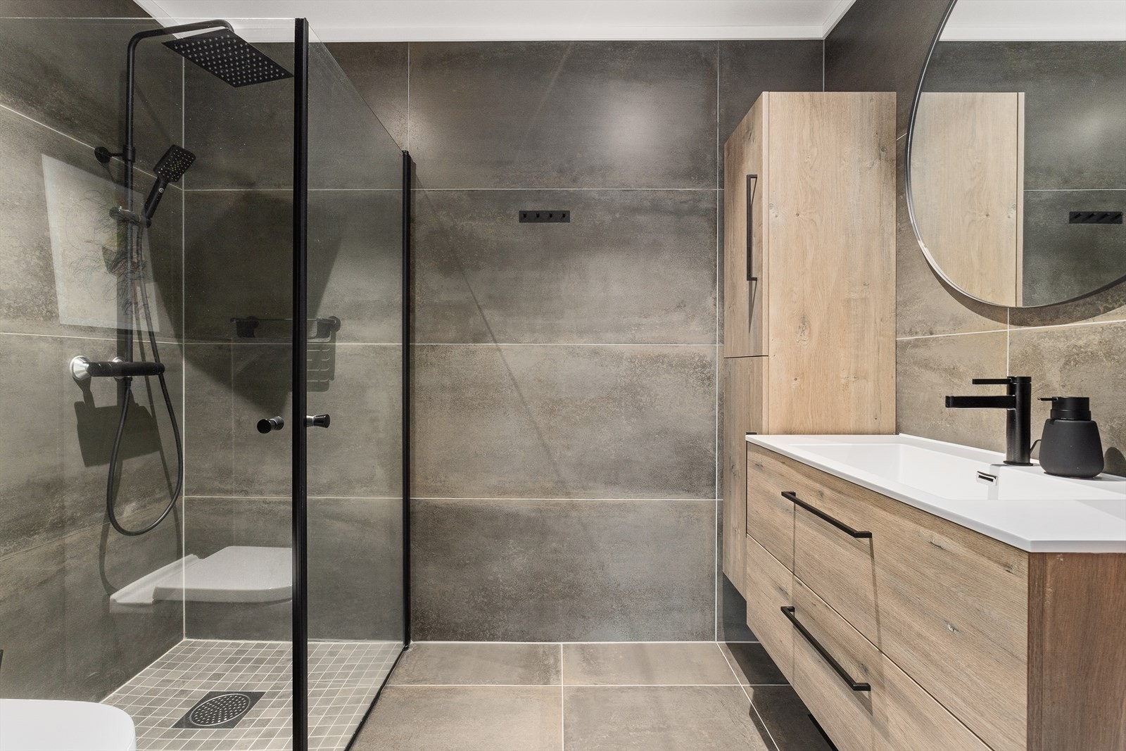 Innbydende helfliset bad med varme i gulv. Downlights i himling. Rommet har innredning med nedfelt servant, veggmontert toalett og dusjvegger/hjørne. Balansert ventilasjon. Galleribilde