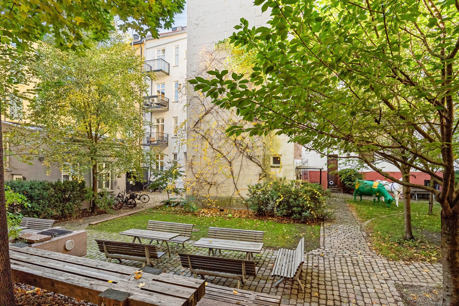 Bakgården er pent opparbeidet med flere sittegrupper, beplantning og felles grill. Galleribilde