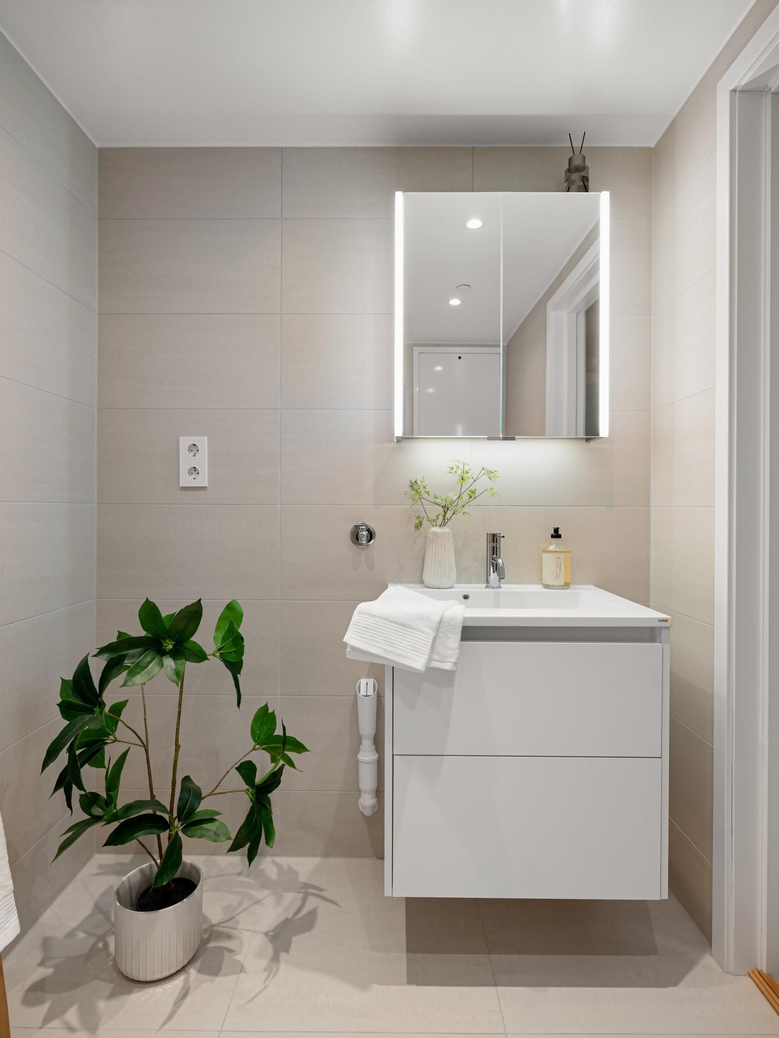 Servant med oppbevaring i skuffesystem under. Opplegg og plass til både vaskemaskin og tørketrommel på venstre side av servanten Galleribilde