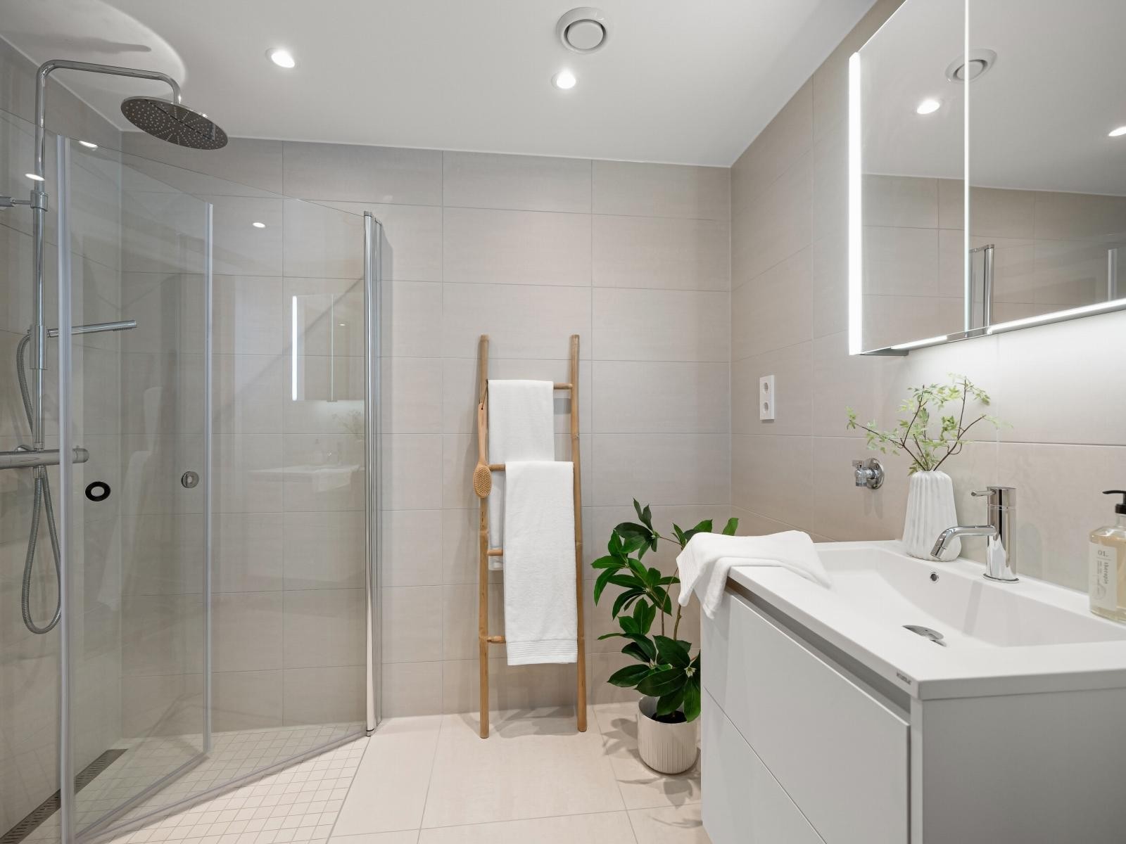 Delikat og tiltalende baderom med stort dusjhjørne med innfellbare glassdører. Galleribilde