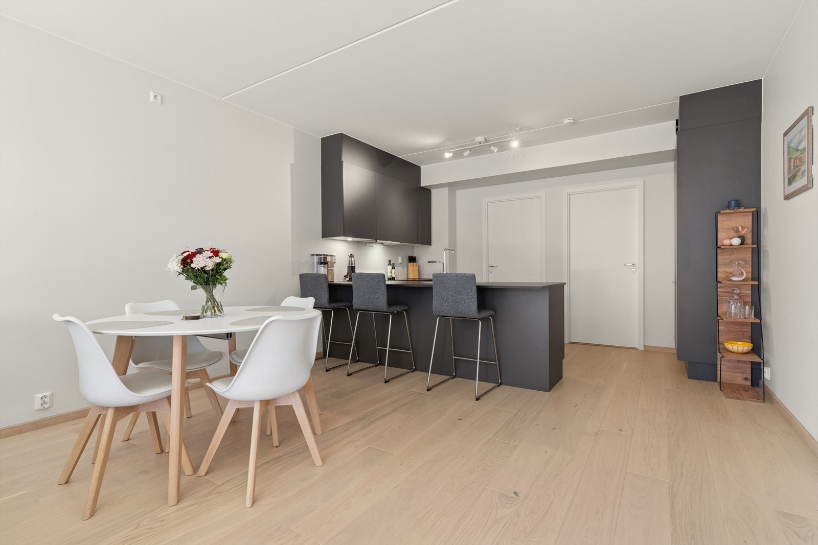 Den åpne løsningen mellom stue og kjøkken skaper en naturlig flyt og legger til rette for både sosiale sammenkomster og hverdagslige gjøremål. Galleribilde