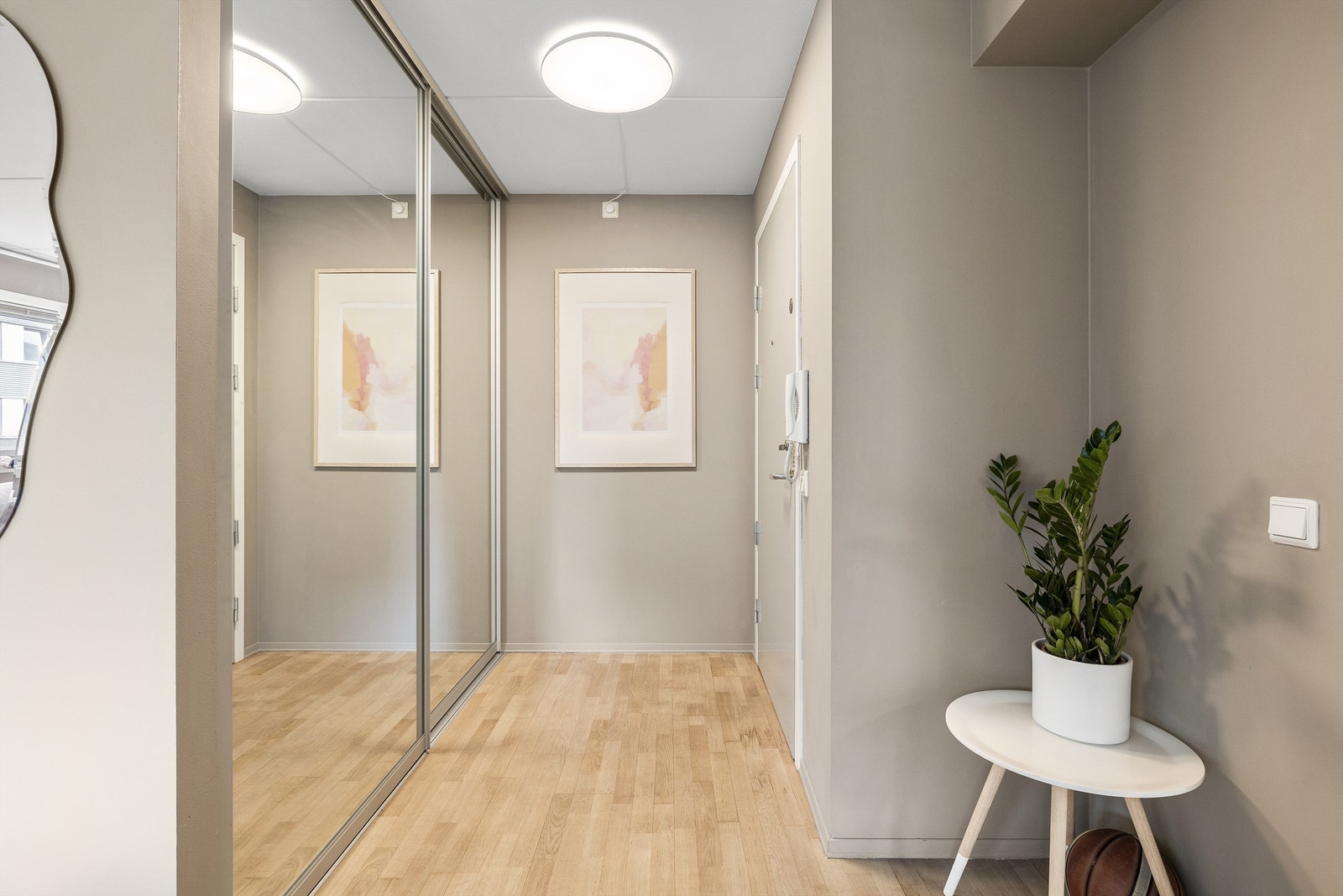 Lys og tiltalende entré med skyvedørsskap for oppbevaring av sko og ytterklær. Galleribilde