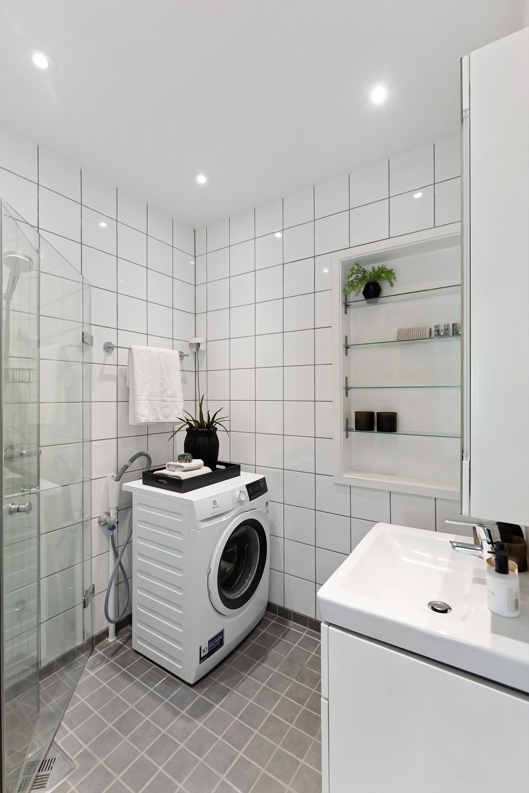 Stilrent bad med fliselagt gulv og varmekabler. Badet ble modernisert i 2017, iht. tidligere salgsoppgave. Hvite fliser på tre av veggene, mens veggen bak vasken er malt mur. Taket er malt, og dimbare downlights fungerer som lyskilde. Galleribilde