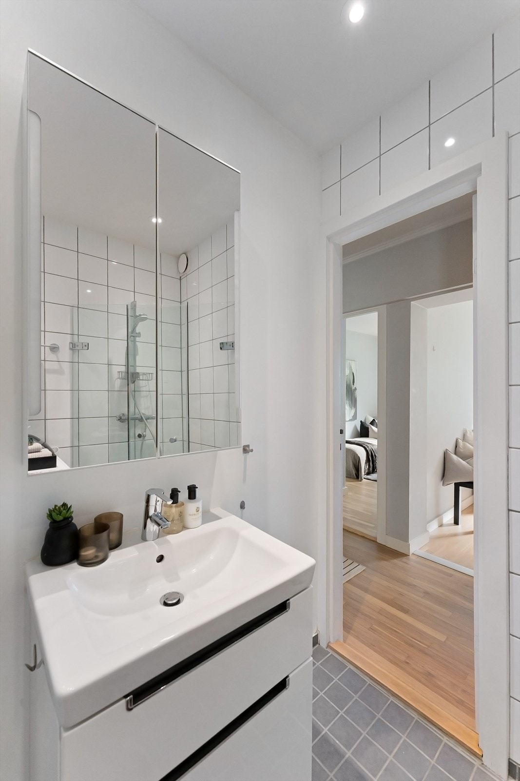 Badet har baderomsinnredning med skuffer og en nedfelt servant med ettgreps blandebatteri. Det er overskap med speil og opplegg for vaskemaskin. Galleribilde