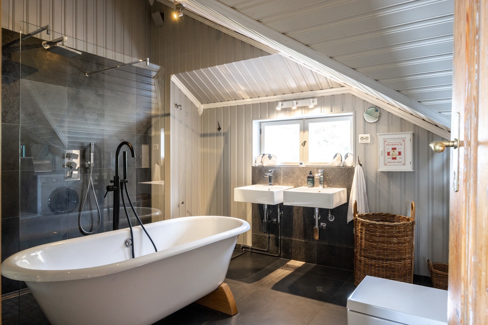 Det romslige badet i andre etasje er stilfullt innredet med fliser på gulv og panel på vegger. Galleribilde