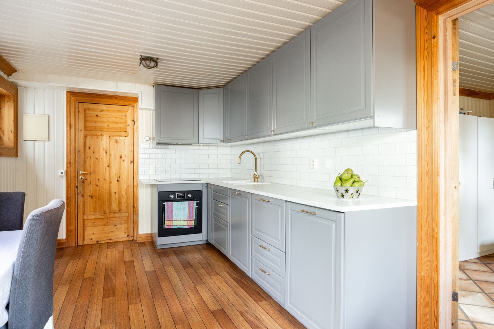 Lys og moderne kjøkkenløsning med profilerte fronter og benkeplate i laminat. Galleribilde