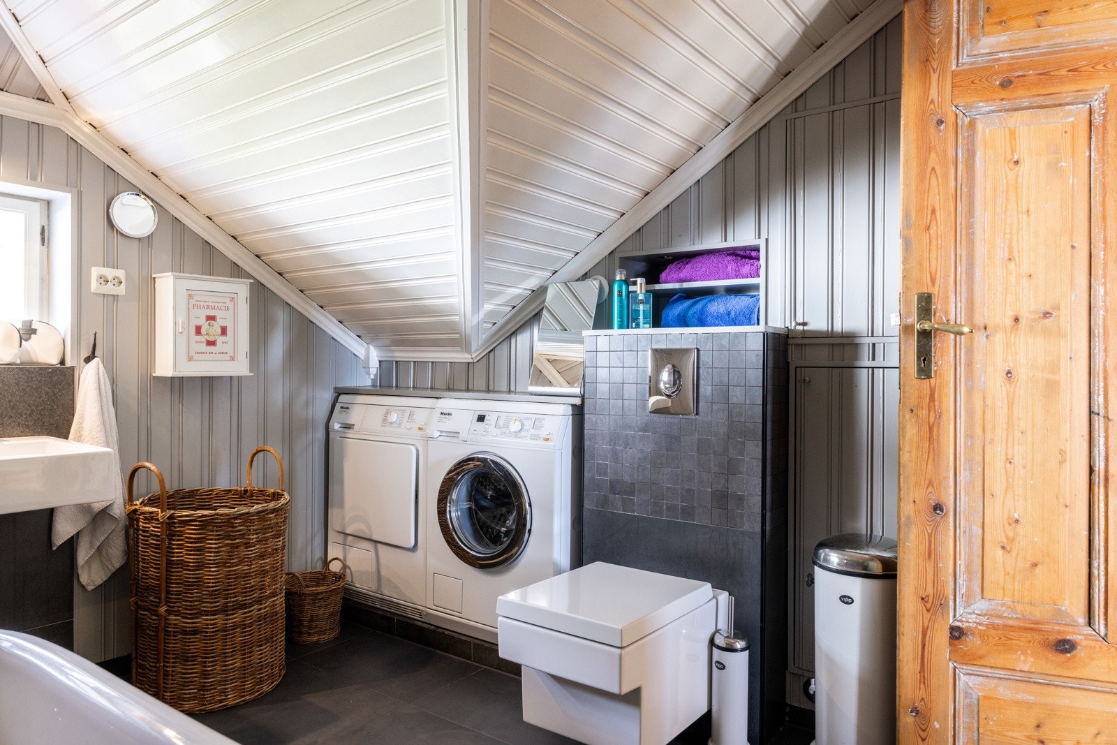 Badet er utstyrt med varmekabler i gulv, vegghengt toalett, dusjnisje med glassvegg, frittstående badekar og dobbel servantinnredning. Galleribilde