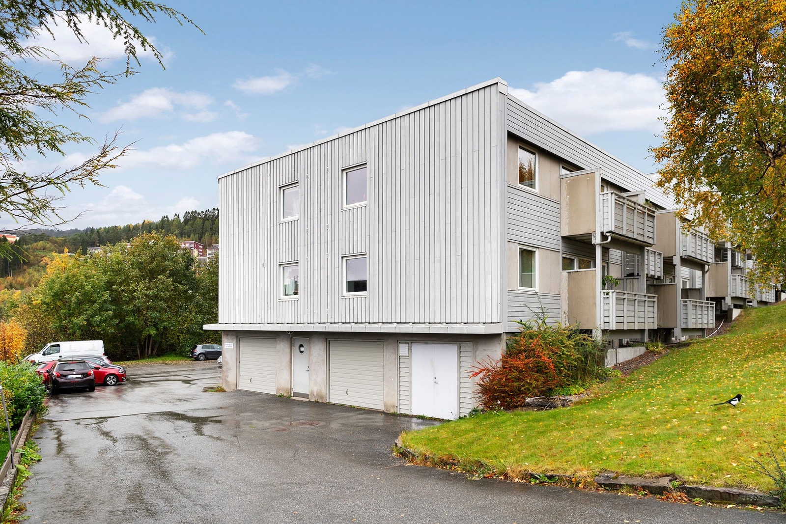 Fasade mot sør - borettslaget har felles parkeringsplasser, hvorav 4 stk har lader for el-bil Galleribilde