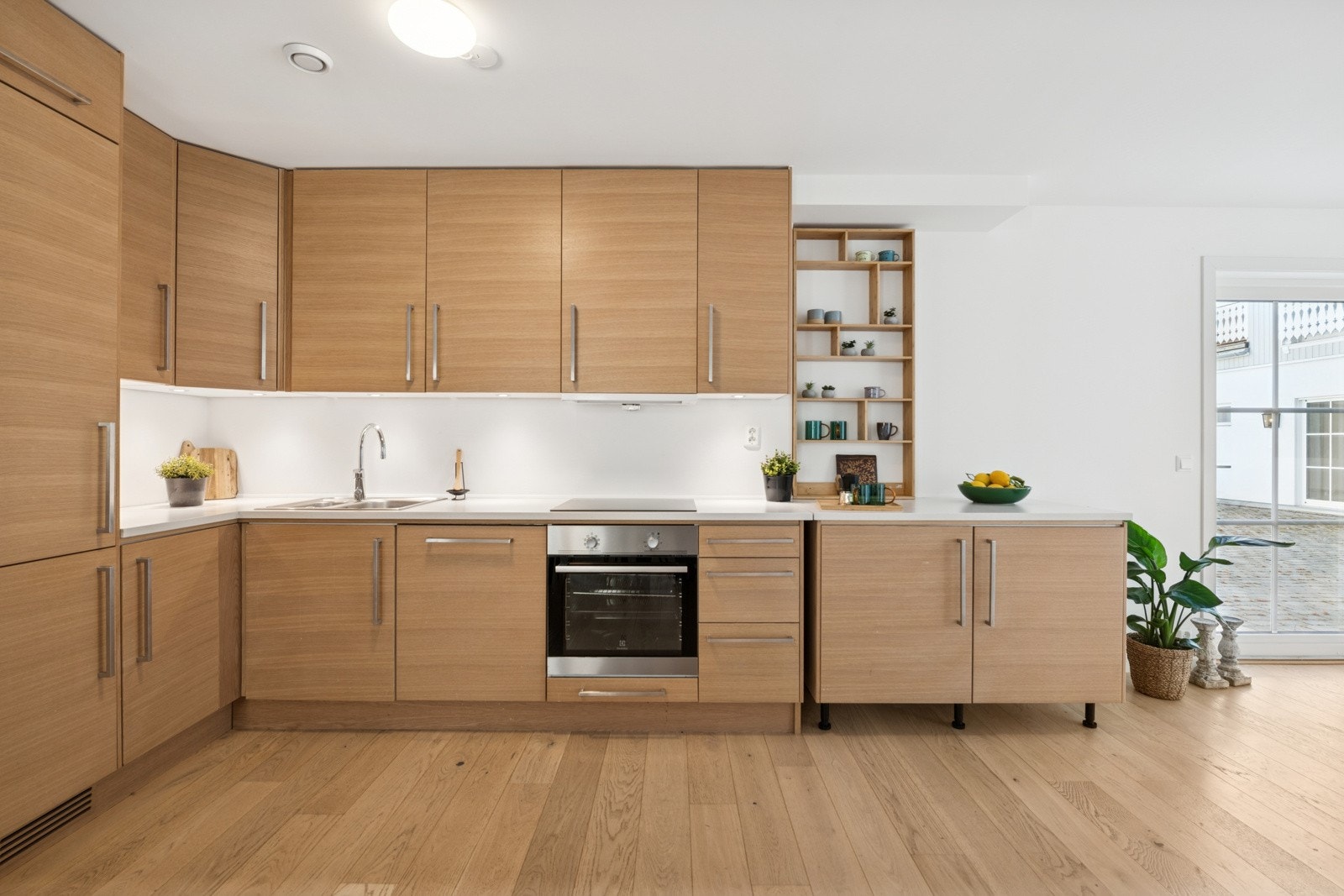 Praktisk og estetisk kjøkken med integrerte hvitevarer og gjennomgående lyse overflater som gir et elegant uttrykk. Galleribilde